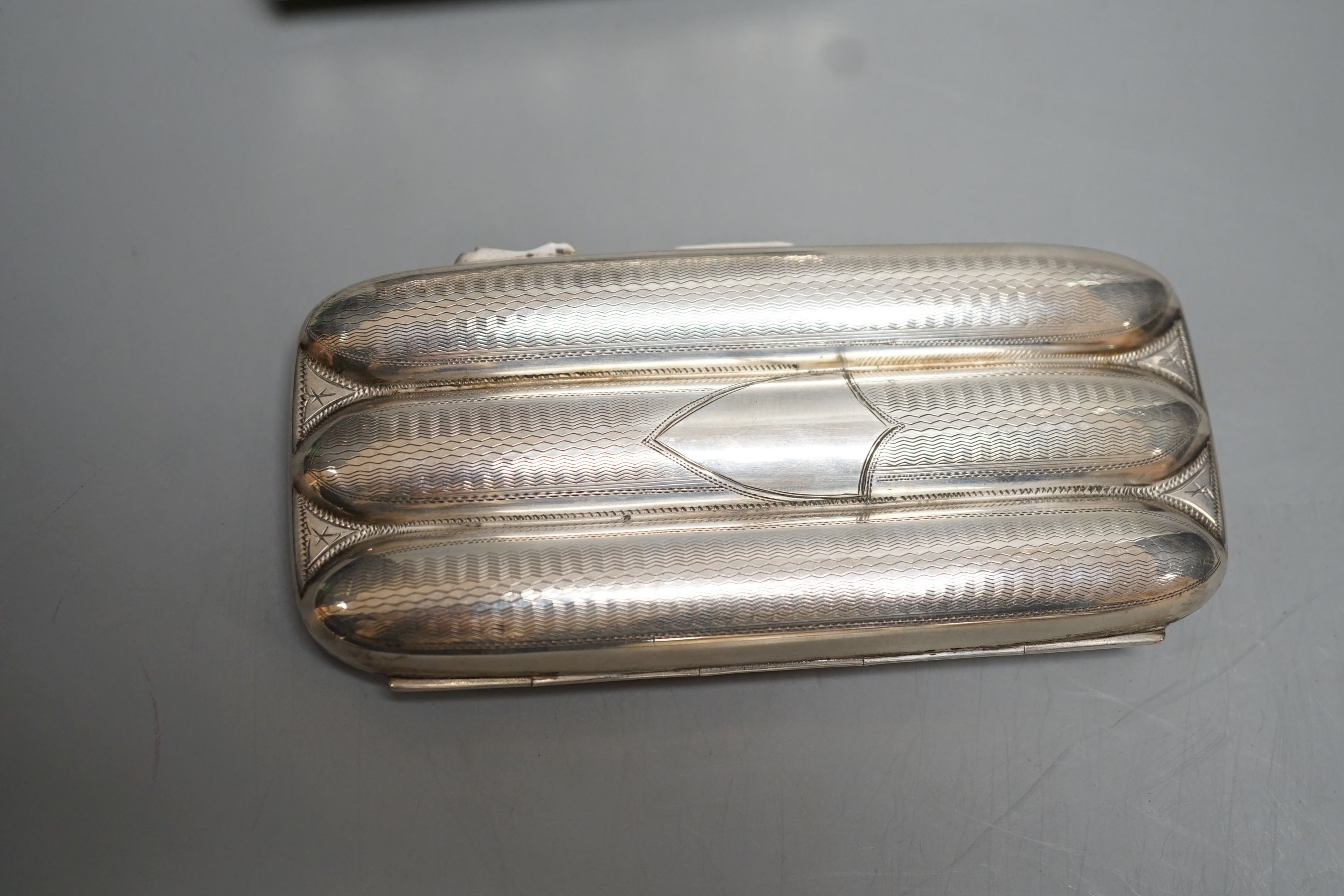 A George V silver three division cigar case, Birmingham, 1915, 13.1cm and a white metal cylindrical purse.